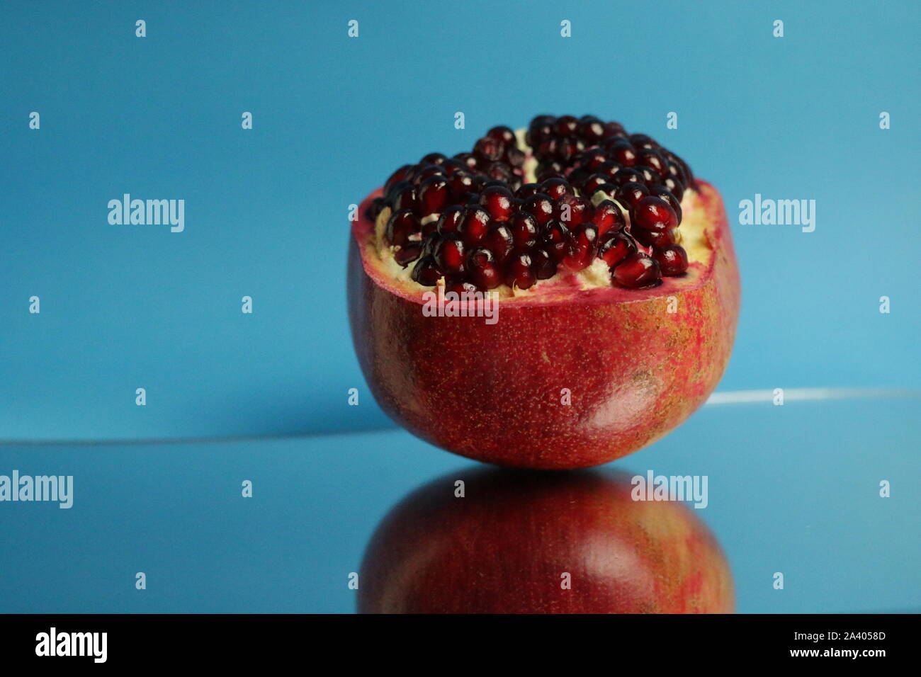 Reife Granatäpfel auf blauem Hintergrund isoliert. Stockfoto
