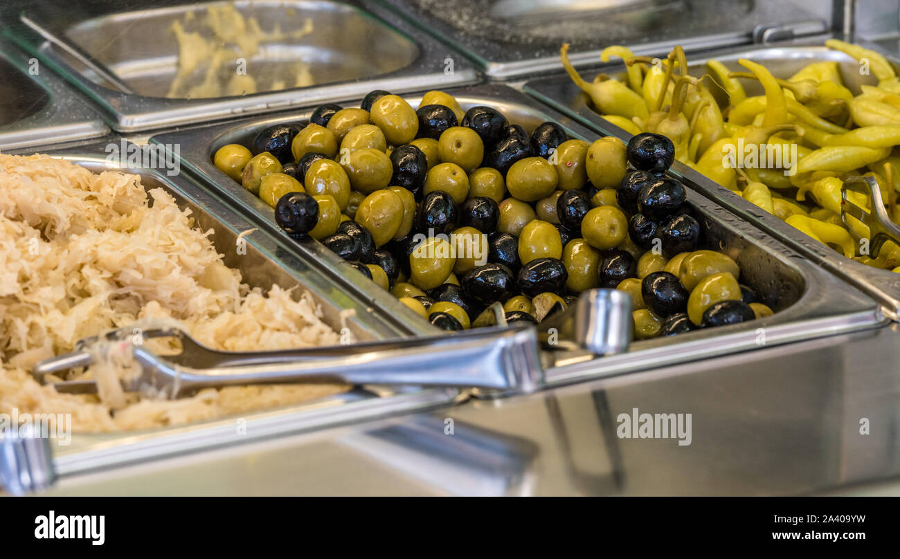 Zutaten auf einen falafel Bar mit Metall Gemüse Zangen grüne Paprika schwarze Oliven grüne Oliven und Kohl Stockfoto