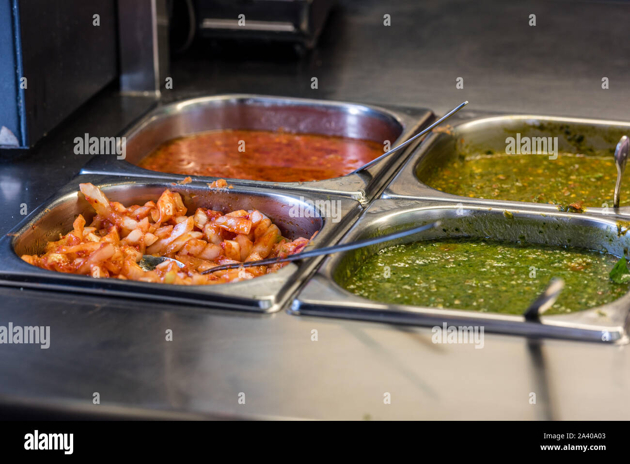 Zutaten auf einen falafel Bar mit Metall Gemüse Zangen und Sauce bar mit Metall Gemüse Zangen und Soßen Stockfoto