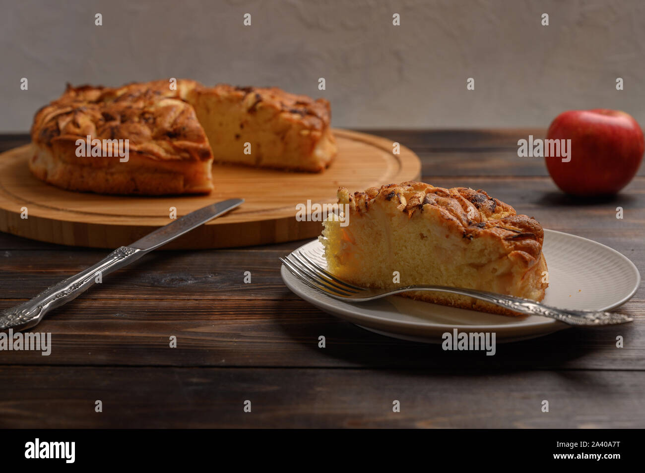 Stück traditionelle hausgemachte Cornwall Torte auf einem Teller. Im Hintergrund eine Torte und einen Apfel Stockfoto