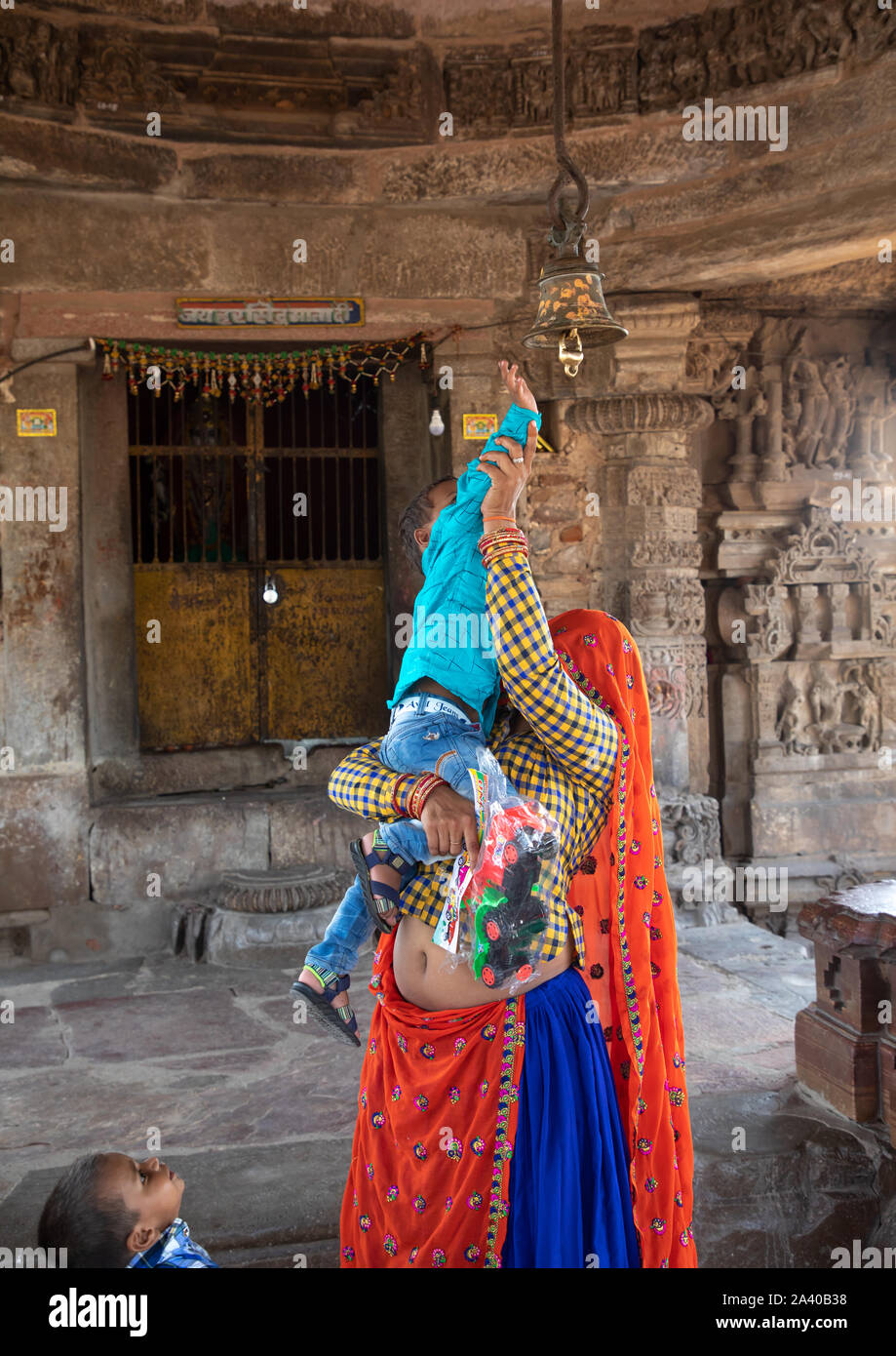Indische Mutter helfen ihr Sohn das Klingeln in Harshat Mata Tempel, Rajasthan, Abhaneri, Indien Stockfoto