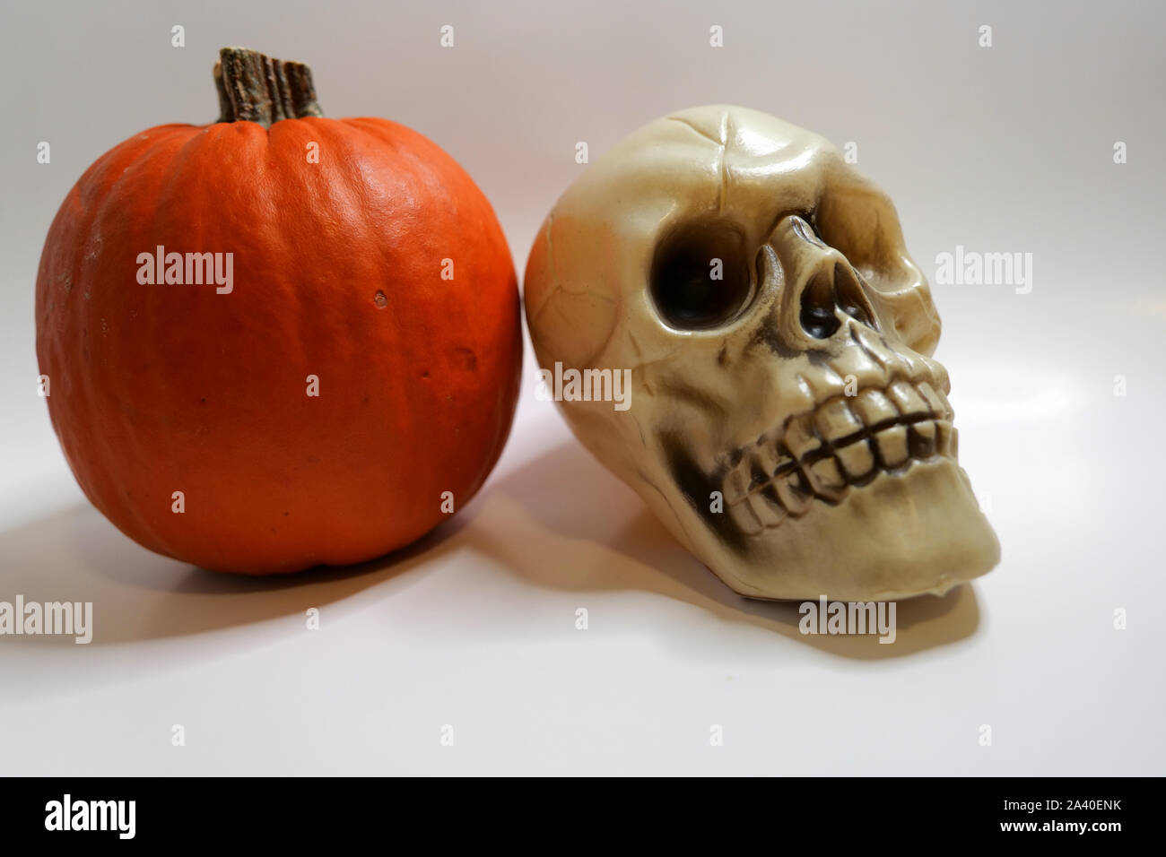Einfaches, günstiges Halloween Mittelstücke eines Schädels und Kürbis auf weißem Hintergrund Stockfoto