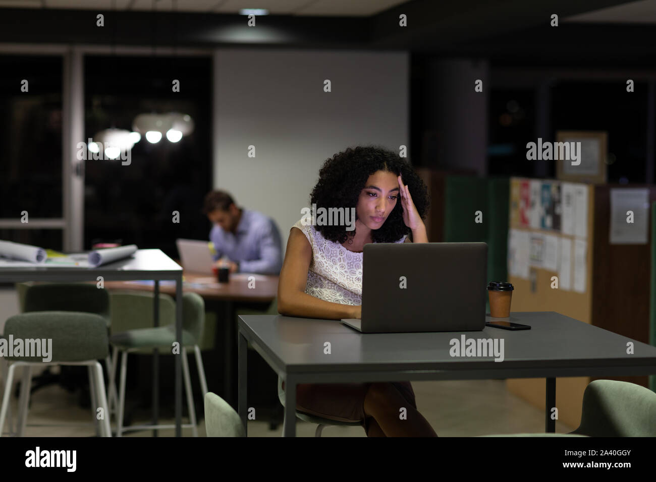 Zwei junge kreative Fachleute, die spät in einem modernen Büro Stockfoto