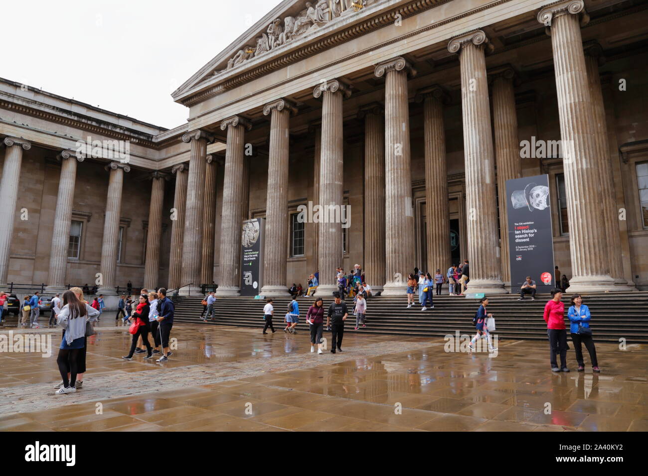 Die Menschen draußen im Vorhof, und vor dem Haupteingang das British Museum in Bloomsbury, London, Vereinigtes Königreich, an einem verregneten Sommer. Stockfoto