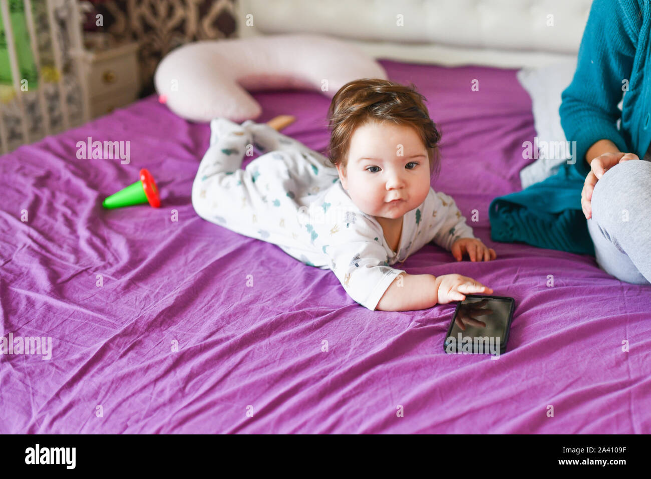 Kleiner Junge hält ein Telefon. Süße kleine Baby hält Handy in seinen Händen und aufmerksam zu betrachten. Kind und Gadget, übergeordnetes Bedienkonzept Stockfoto