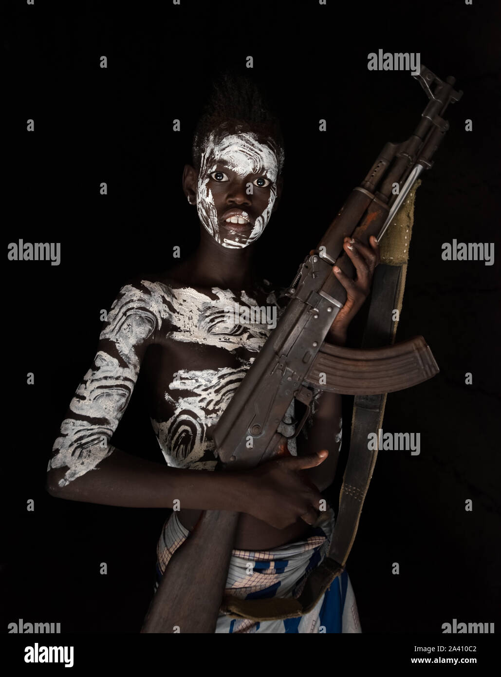 Äthiopien: Ein junger Krieger wiegen ein AK 47. Schockierende Bilder zeigen die seltsamen Sitten der Stämme in der Omo Valley, wo Frauen geschlagen, BIS DIE Stockfoto