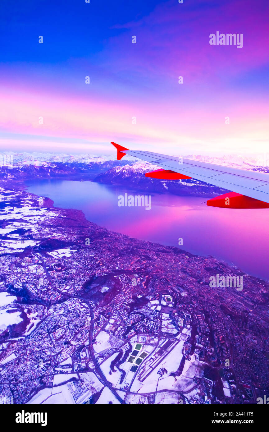 Blick aus dem Flugzeug Fenster während der Sonnenuntergang über den Bergen in der Schweiz Stockfoto