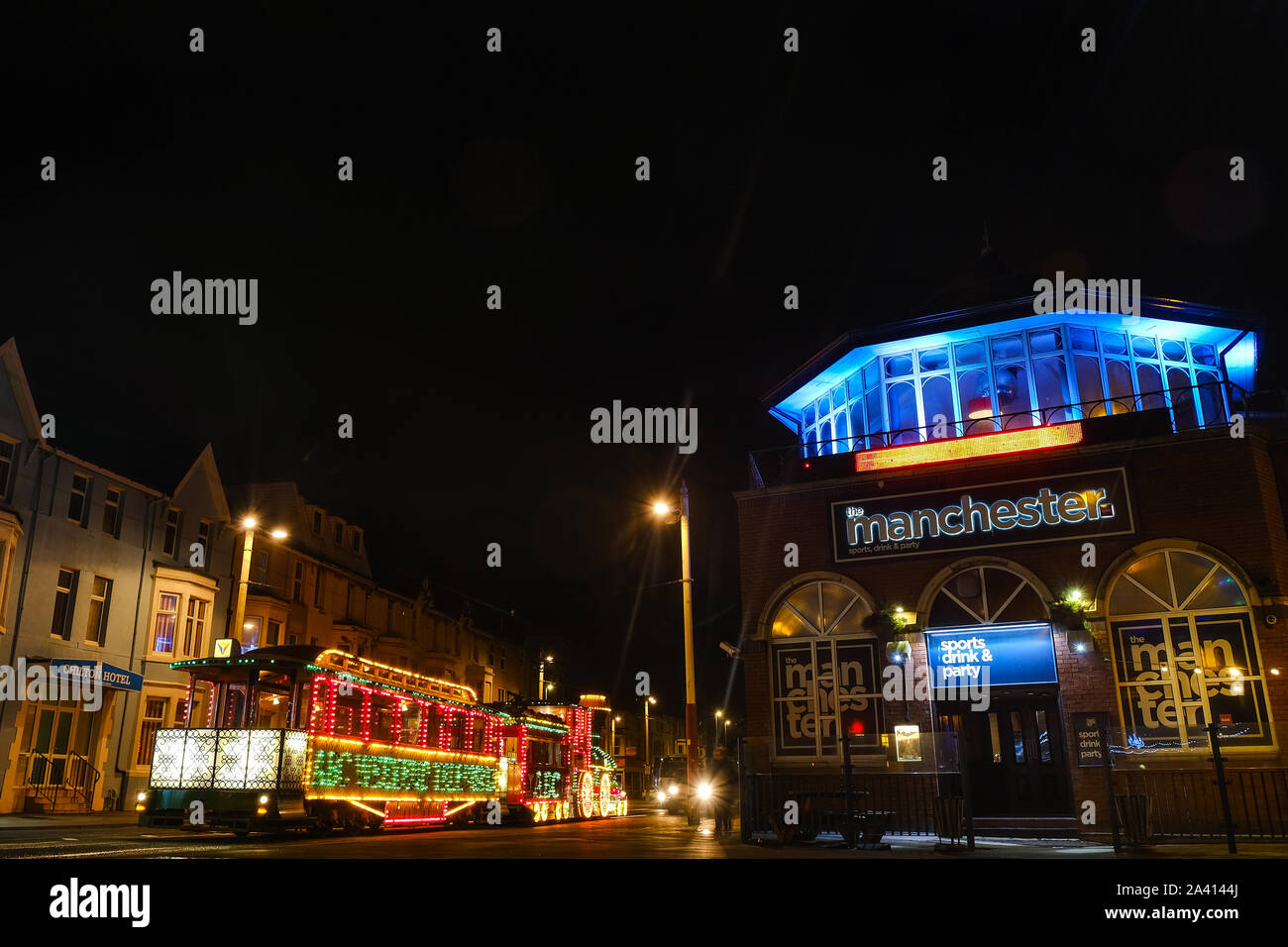 Eine beleuchtete Blackpool Tram vorbei an der Manchester, ein Pub in der Stadt während der illuminationen. Stockfoto