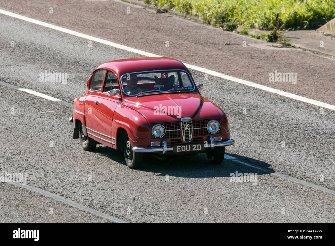 Red Saab 96 v4; Reisen auf der Autobahn M6 in der Nähe von Preston in Lancashire, Großbritannien Stockfoto