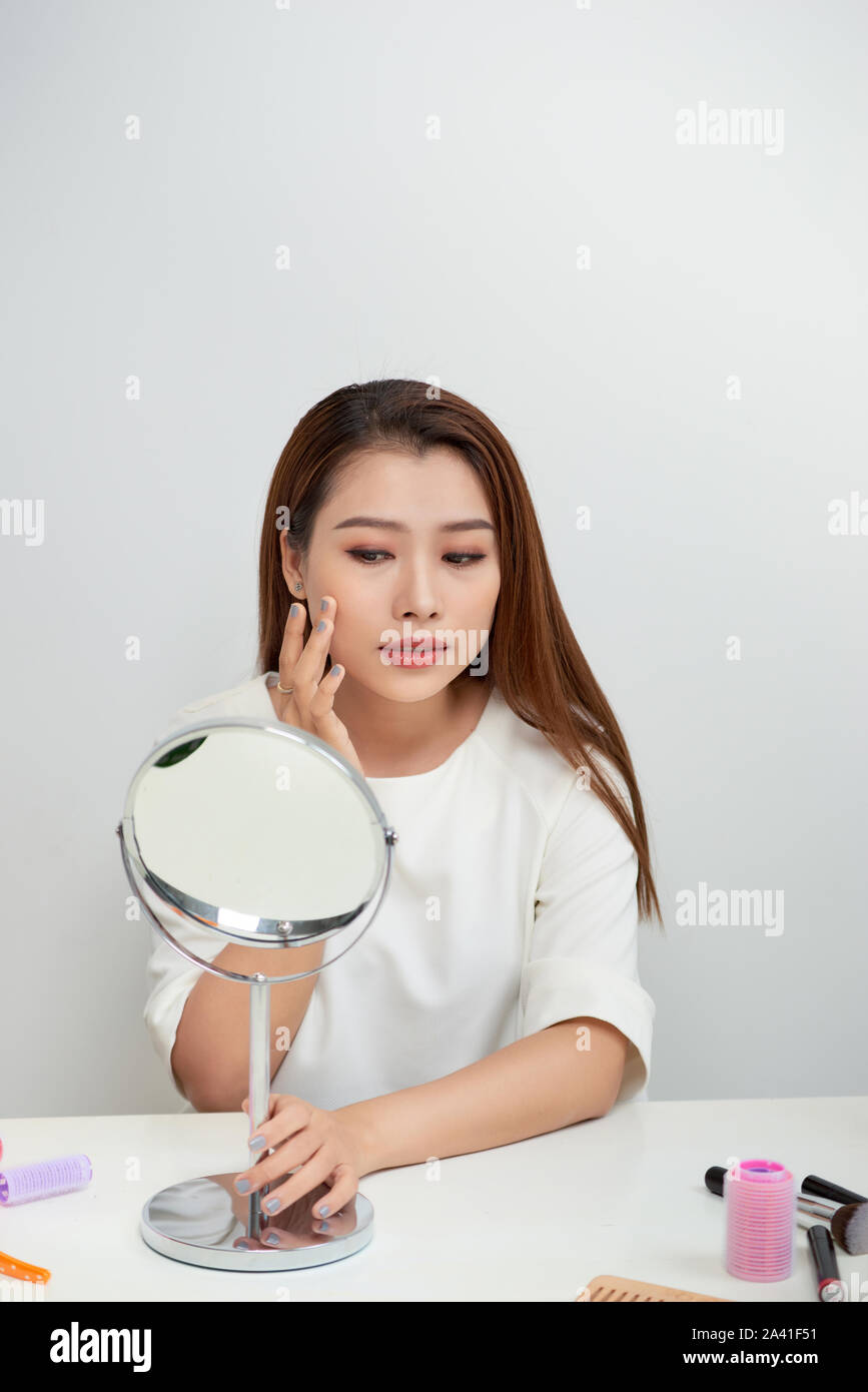 Junge asiatische Frau auf der Suche nach einem Spiegel. Stockfoto