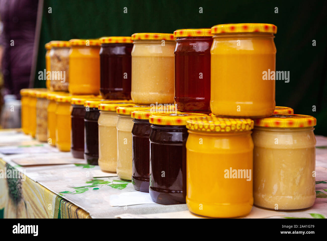 Natürlicher Honig in Gläsern auf dem Markt. Gläser mit verschiedenen Arten von puren, rohen, frischen Honig. Gläser mit verschiedenen Sorten von Honig. Stockfoto