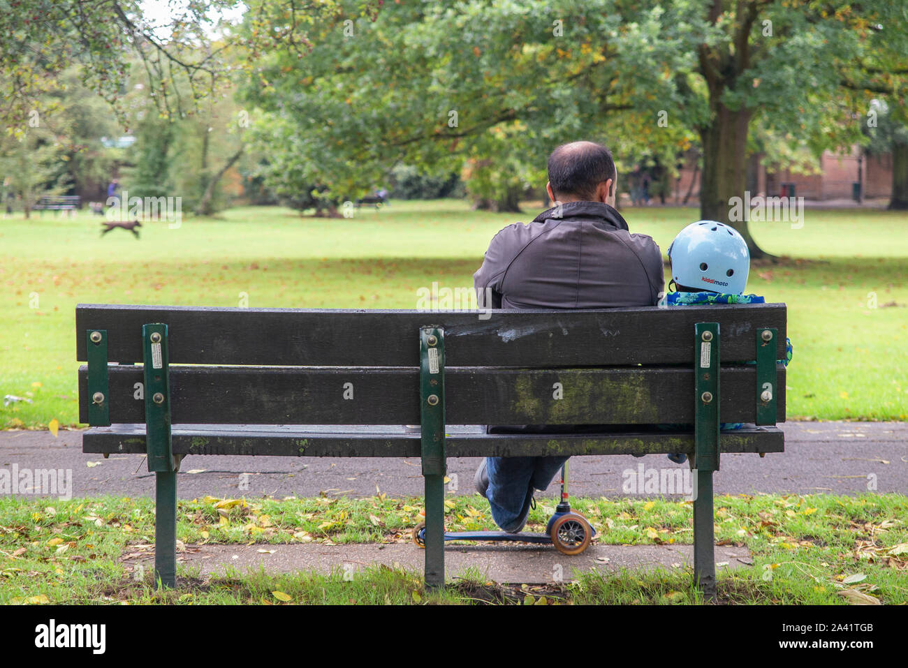 Ein liebevoller Moment zwischen Vater und Sohn auf einer Parkbank Stockfoto