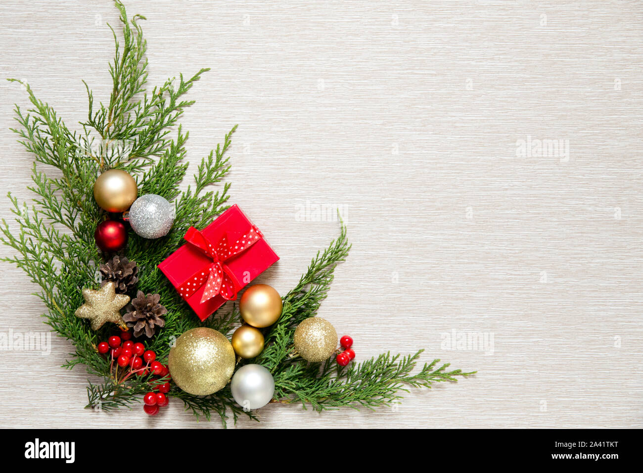 Grüne Zweige und Weihnachtskugeln. Weihnachten Dekor auf einem hellen Hintergrund. New Year's Geschenk in einer kleinen roten Box. Stockfoto