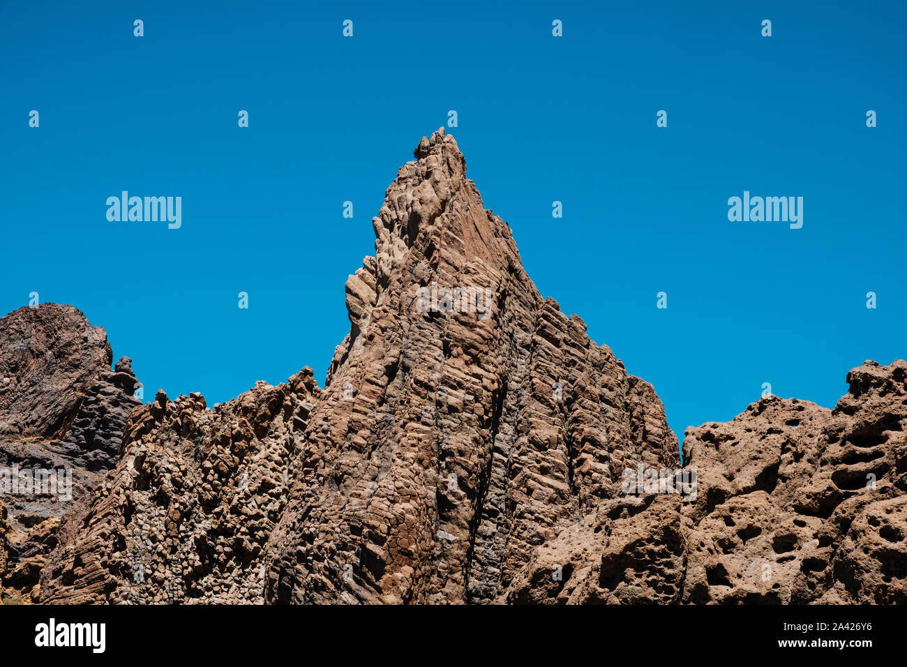 Vulkangestein, geschichteten vulkanischen Felsen in der Wüste mit Berge und blauer Himmel Stockfoto