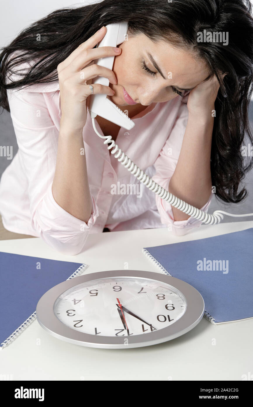 Frau am Telefon gerade eine Uhr mit einer Frist nähert sich Stockfoto
