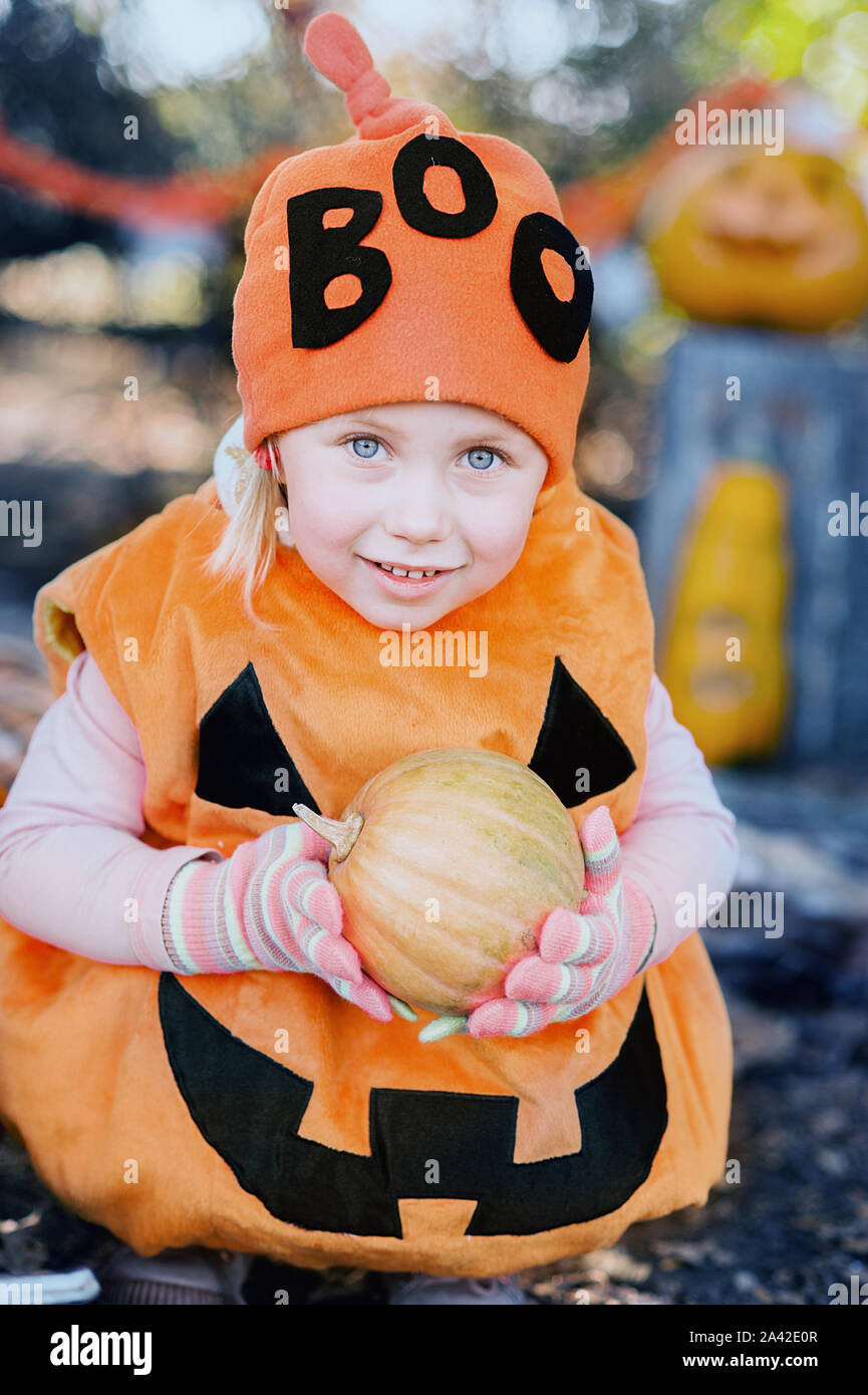 Happy kleines Mädchen in halloween kostüm Holding Kürbis. tick oder behandeln Stockfoto