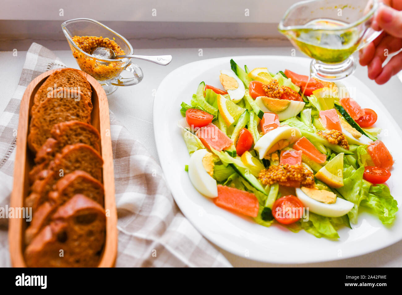 Salat mit Brot und Senf. auf einem weißen Teller. Ansicht von oben Stockfoto