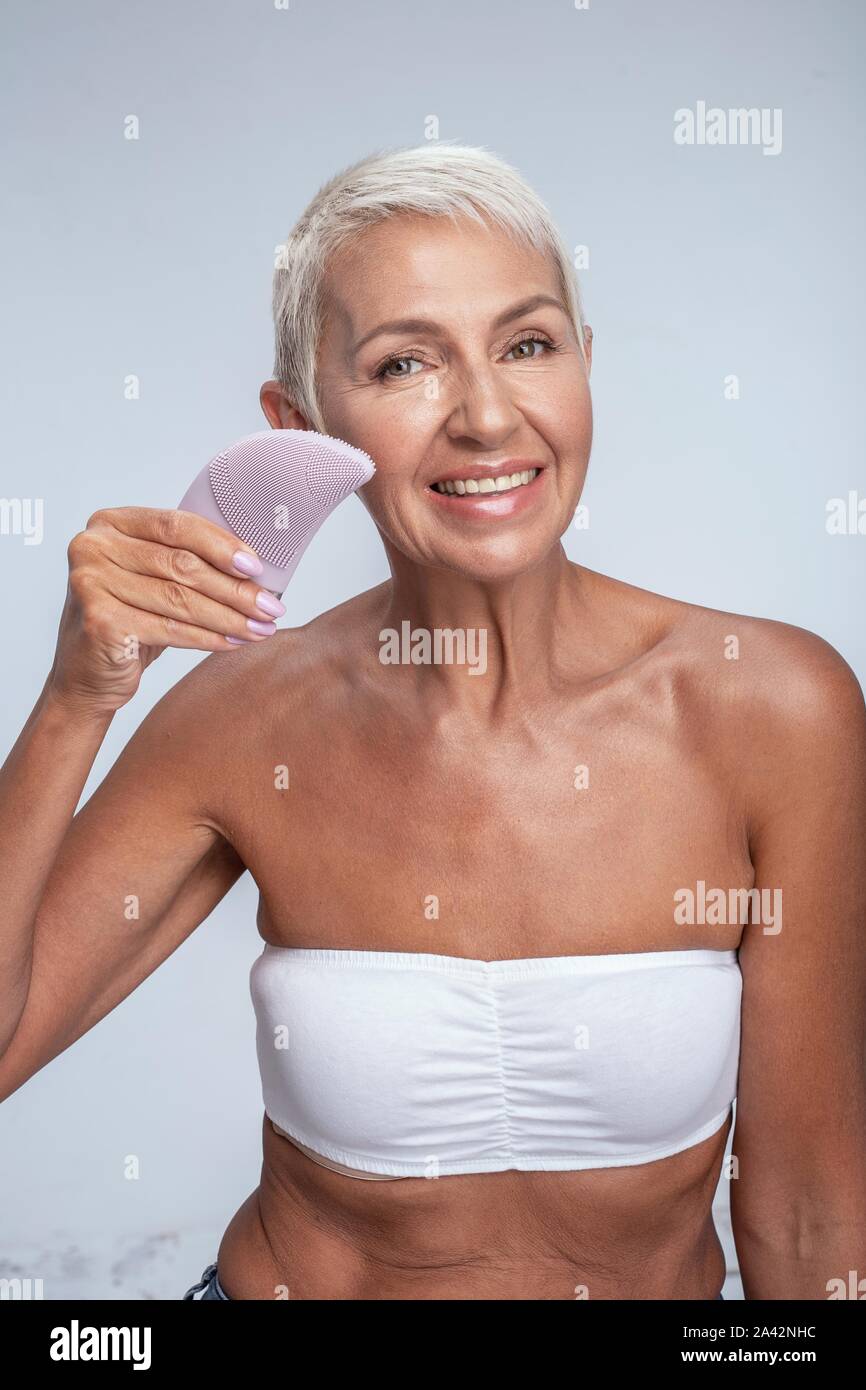 Portrait einer hübschen Frau mittleren Alters posing und Förderung sauberer Gesicht Stockfoto
