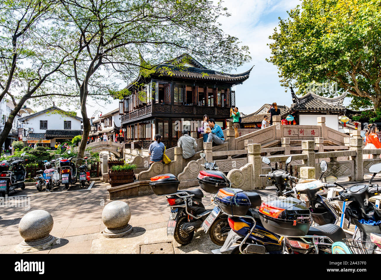 Shanghai Nanxiang Altstadt Canal City Jili Brücke mit Sitzen Menschen und Motorräder auf einem sonnigen blauen Himmel Tag Stockfoto