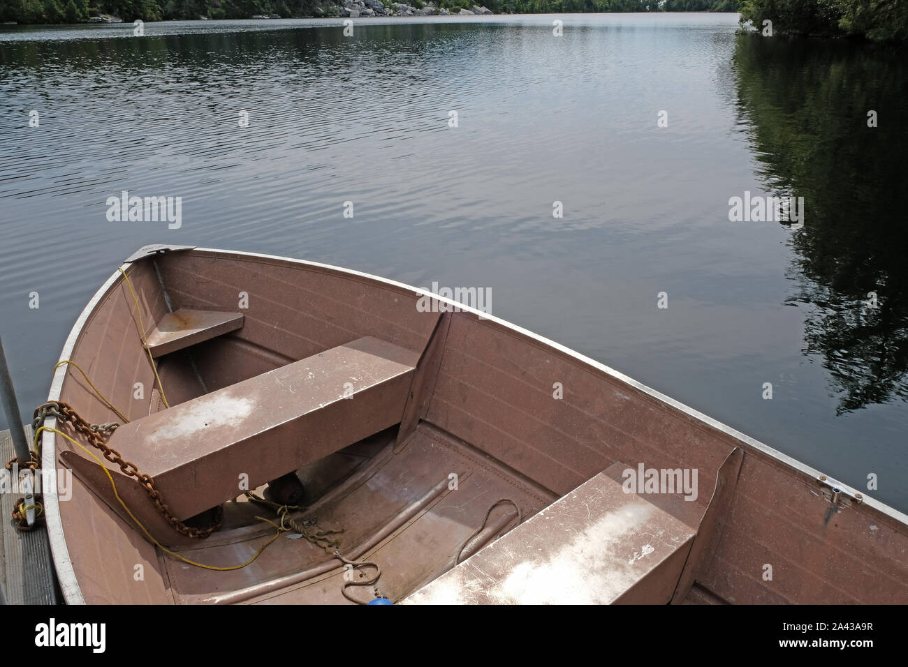 Alte rosa Beiboot/Ruderboot angedockt am Pier am See Stockfoto