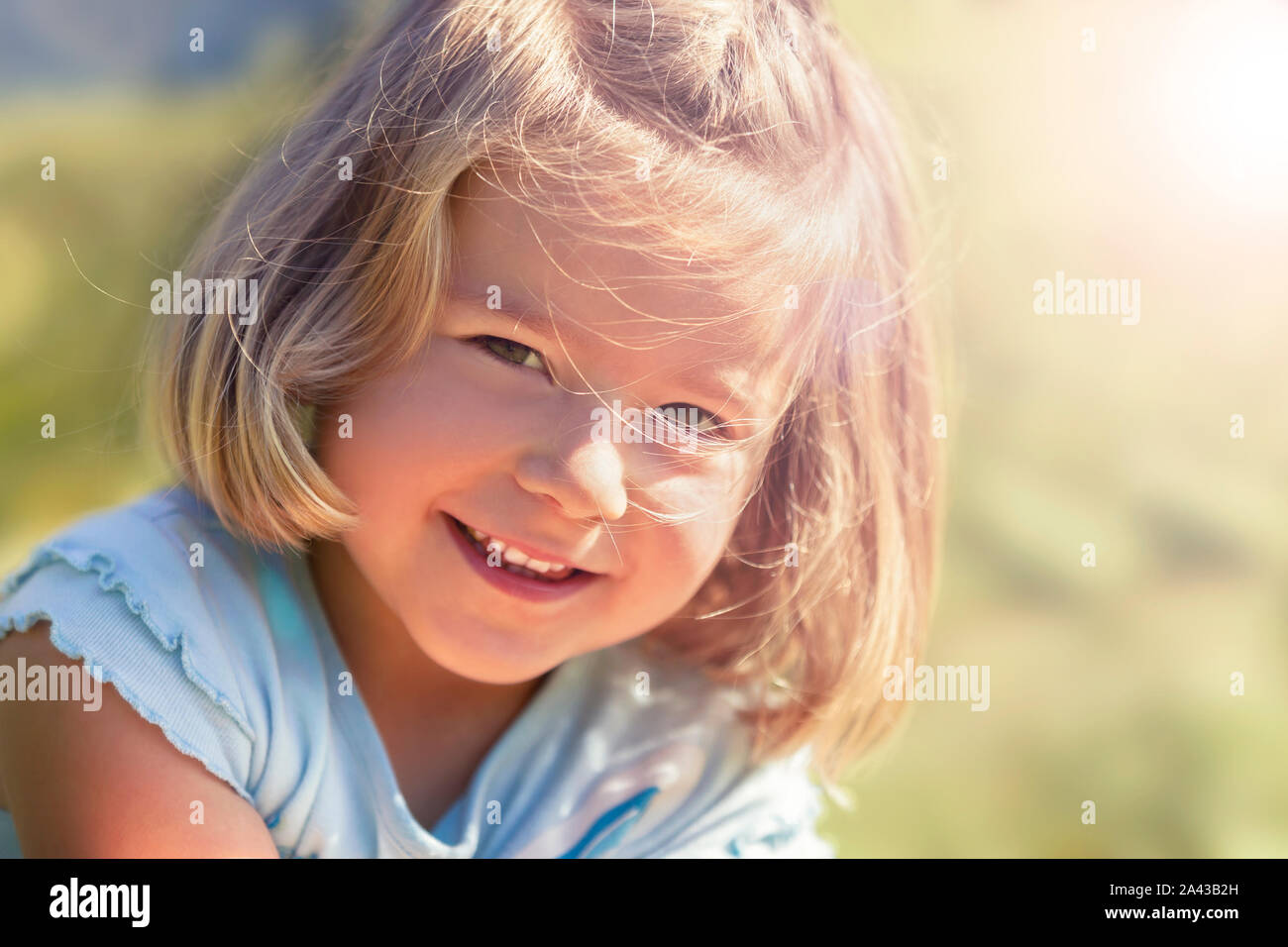 Bezaubernd lächelnde Mädchen draussen in der Natur. Stockfoto