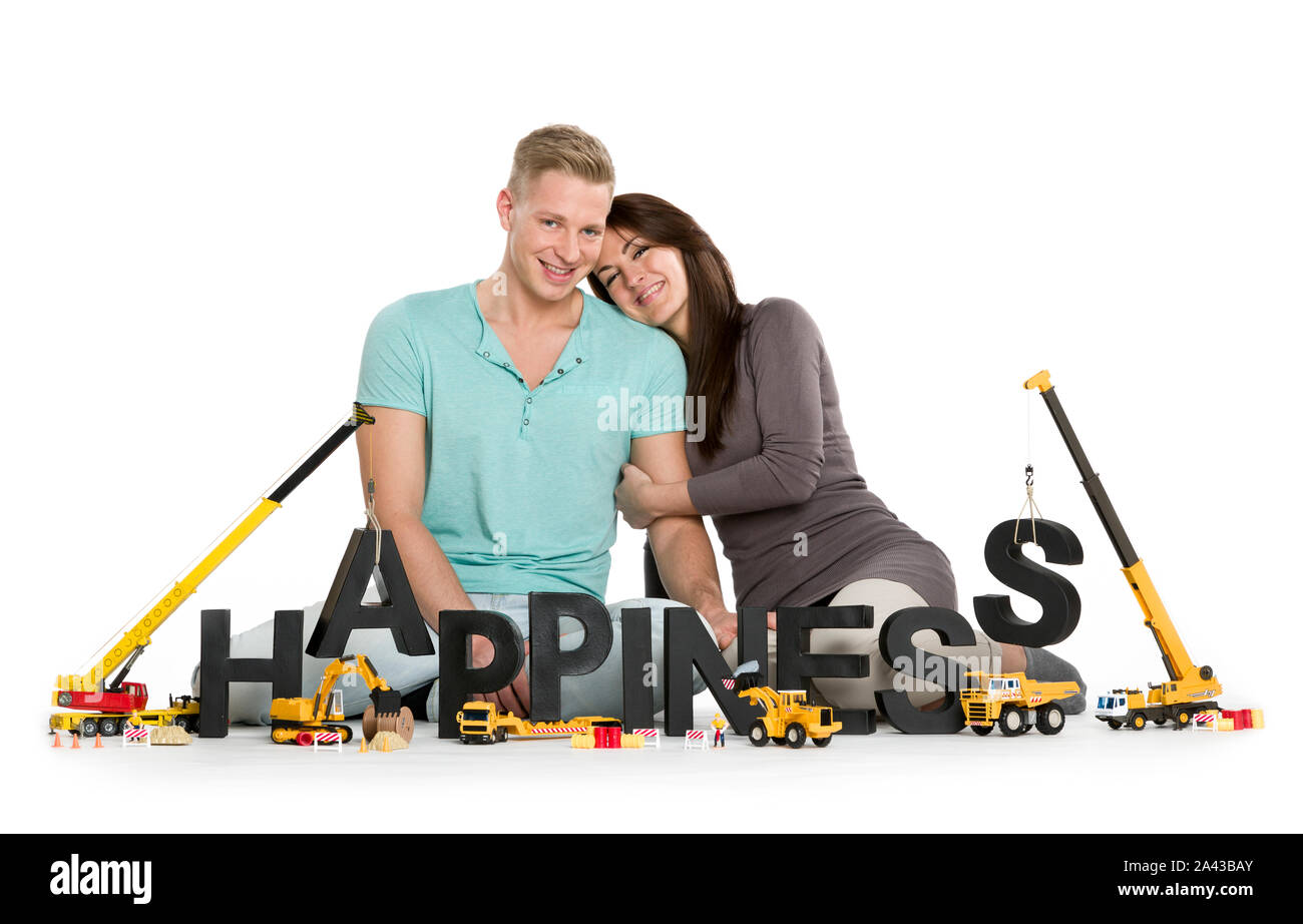 Glücklich lächelnde Frau und Mann Gebäude Glück - Wort. Stockfoto