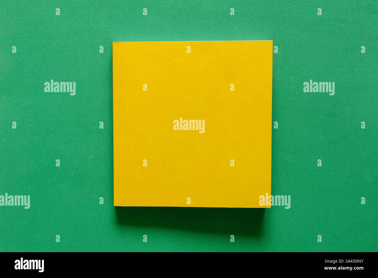 Gelbes Quadrat Buch über raue Grün matt Tabelle Stockfoto