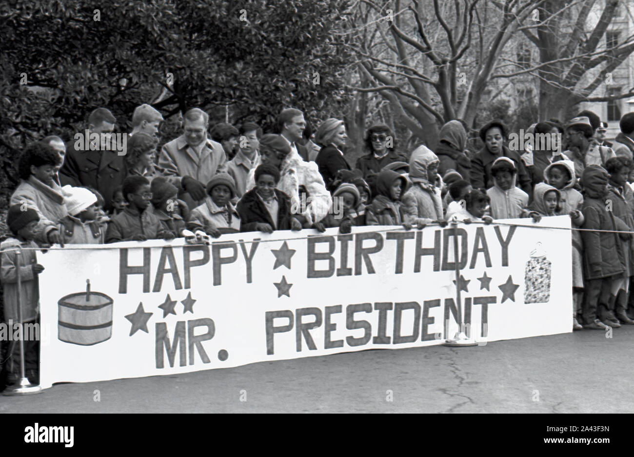 Washington DC. USA, Februar 5, 1984 lokale Schule Kinder halten einen Geburtstag banner während des Wartens Präsident Ronald Reagan und First Lady Nancy Reagan nach ihrer Rückkehr aus Camp David zu begrüßen Stockfoto