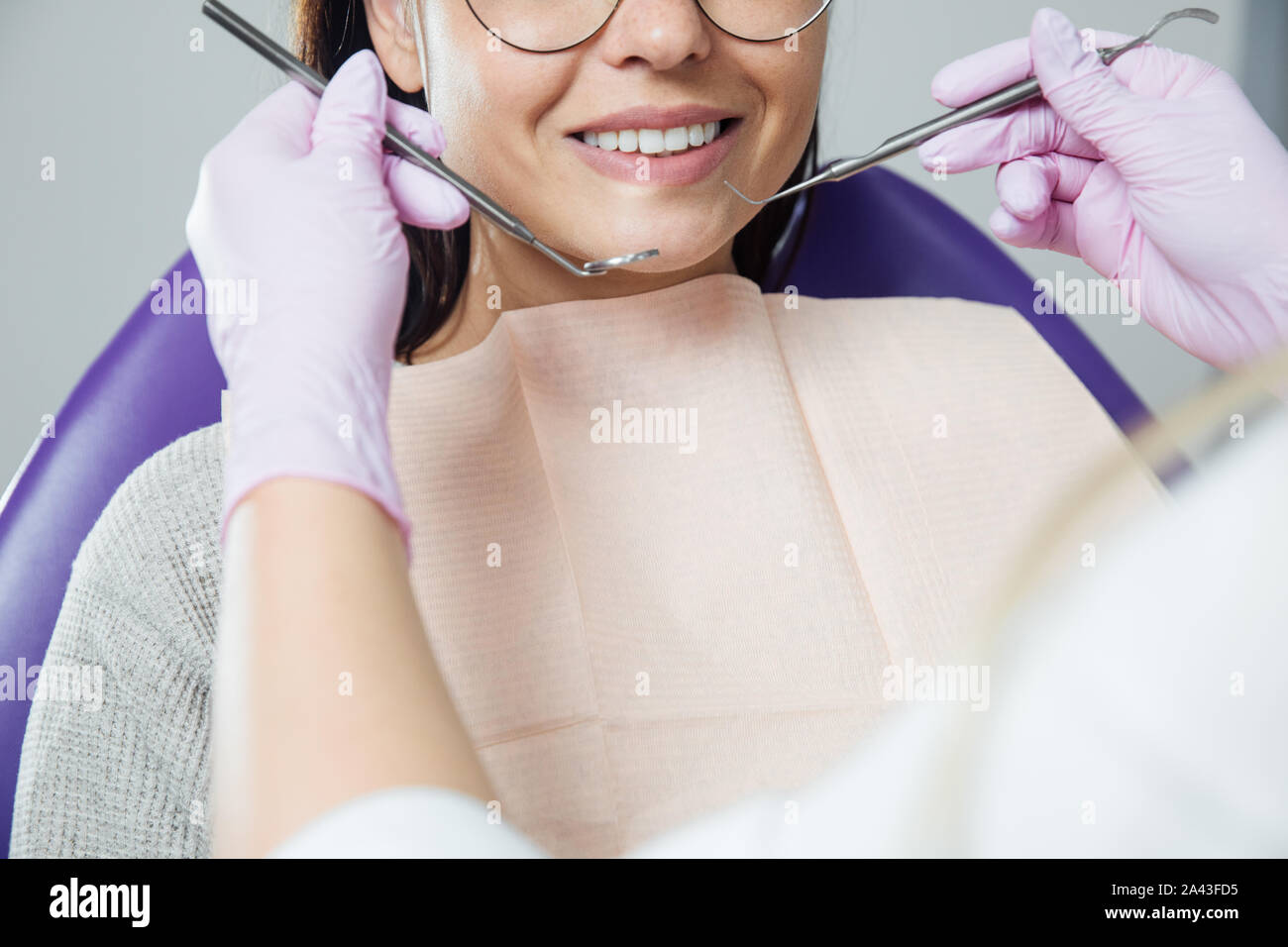 Eine Frau ist die Vorbereitung für eine zahnärztliche Untersuchung. Frau, die Zähne Zahnärzte untersucht. Stockfoto