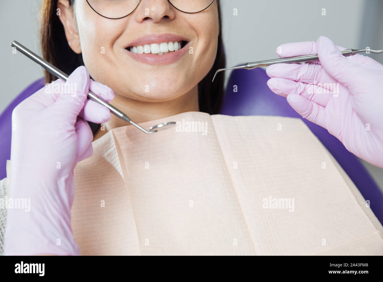 Eine Frau ist die Vorbereitung für eine zahnärztliche Untersuchung. Frau, die Zähne Zahnärzte untersucht. Stockfoto