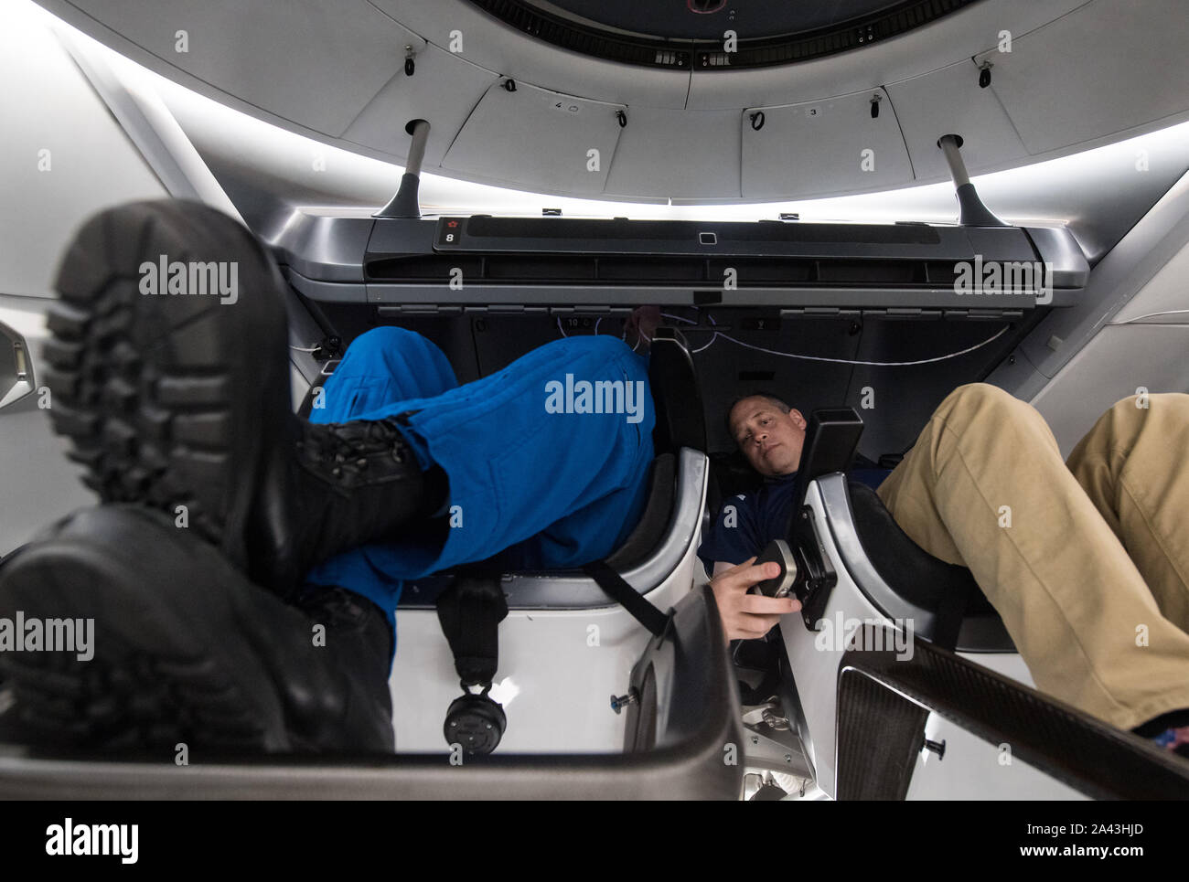 Hawthorne, Vereinigten Staaten von Amerika. 10. Oktober, 2019. NASA-Administrator Jim Bridenstine, rechts, sitzt in einem MOCKUP der Demo-2 Crew Dragon mit NASA-Astronaut Bob Behnken während einer Tour der SpaceX Hauptsitz Oktober 10, 2019 in Hawthorne, Kalifornien. Credit: Aubrey Gemignani/NASA/Alamy leben Nachrichten Stockfoto