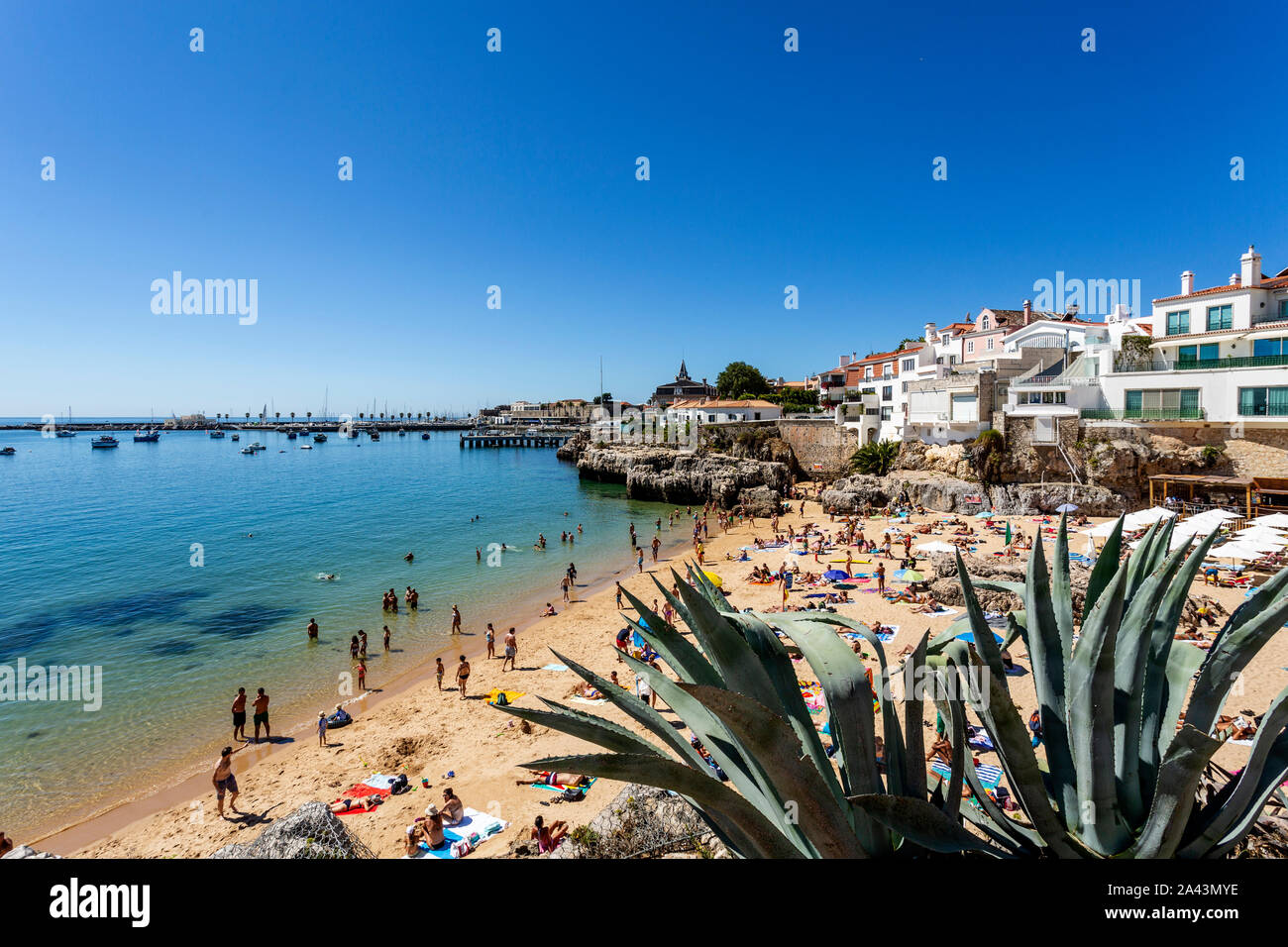 Blick auf die überfüllten hübschen kleinen Strand "Praia da Rainha entlang der Strandpromenade zwischen Estoril und Cascais, in der Nähe von Lissabon, Portu Stockfoto