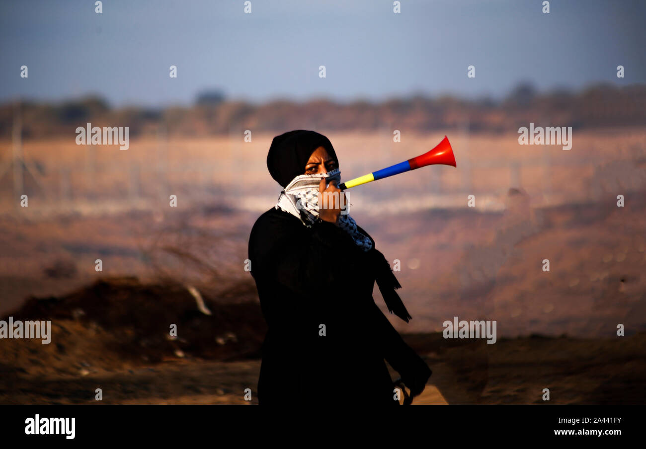 Eine palästinensische Demonstrator verwendet einen Signalton die israelischen Streitkräfte während einer anti-israelischen Demonstration für ein Ende der Jahre der Belagerung auf der Israel-Gaza Grenze im südlichen Gazastreifen zu stören. Stockfoto