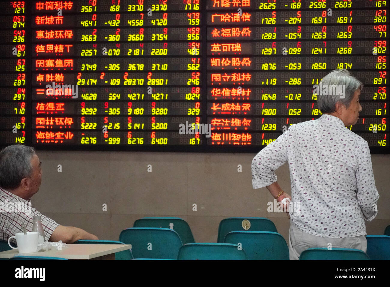 Zwei ältere Personen beobachten Sie die Börse mit einem Makler Unternehmen in Nanjing in der ostchinesischen Provinz Jiangsu, 26. August 2019. Stockfoto
