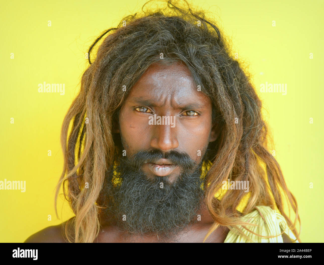 Scruffy untere Kaste der tamilischen Bettler mit Dreadlocks und schwarzen Bart posiert für die Kamera. Stockfoto