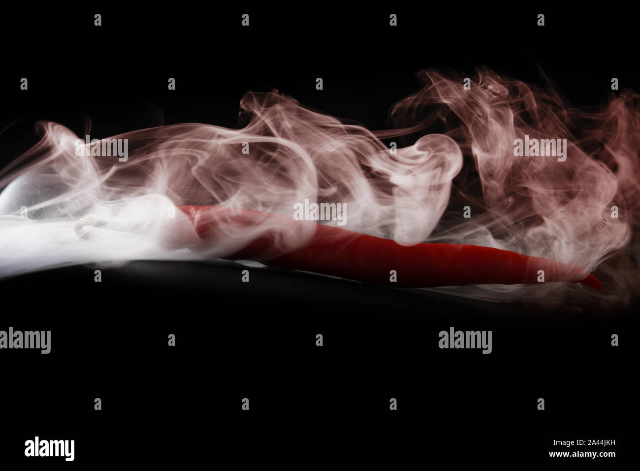 Einfache Rauch auf schwarzem Hintergrund mit rotem Pfeffer Stockfoto