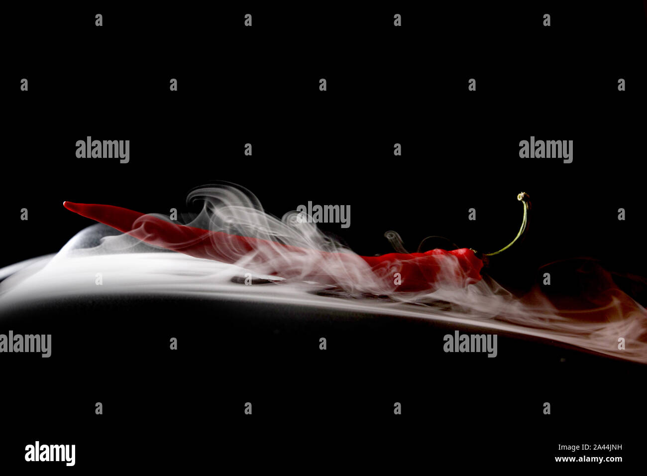 Einfache Rauch auf schwarzem Hintergrund mit rotem Pfeffer Stockfoto