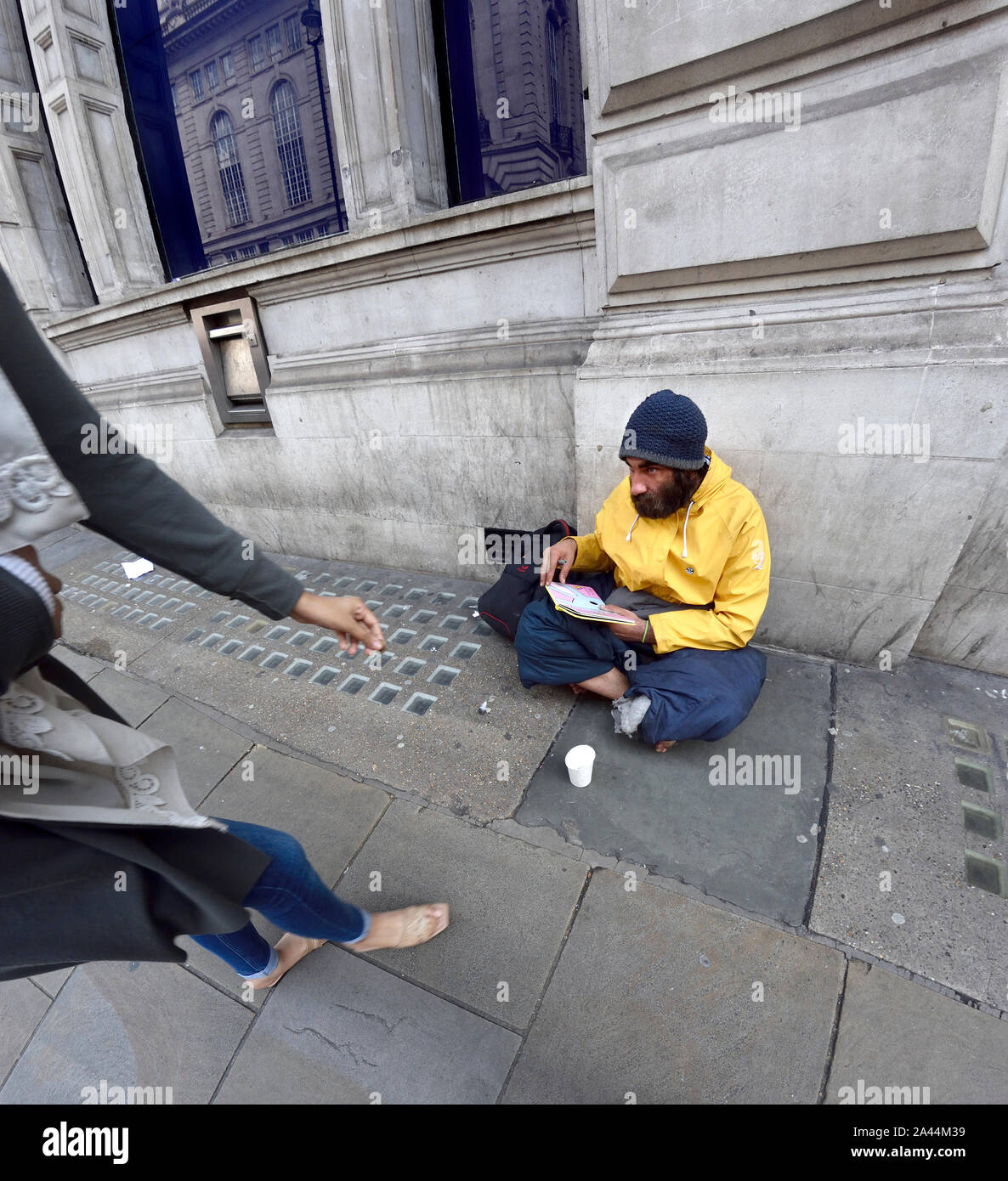 London, England, UK. Frau Geld zu geben, einen Obdachlosen Stockfoto
