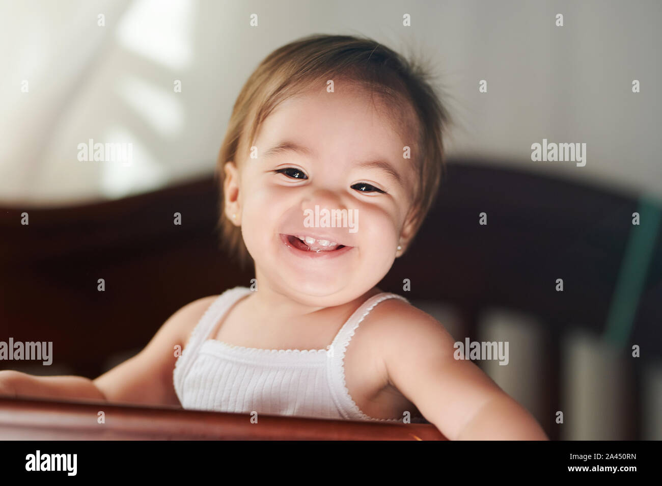 Lachend glückliches Kind im weißen T-Shirt in Kamera suchen Stockfoto