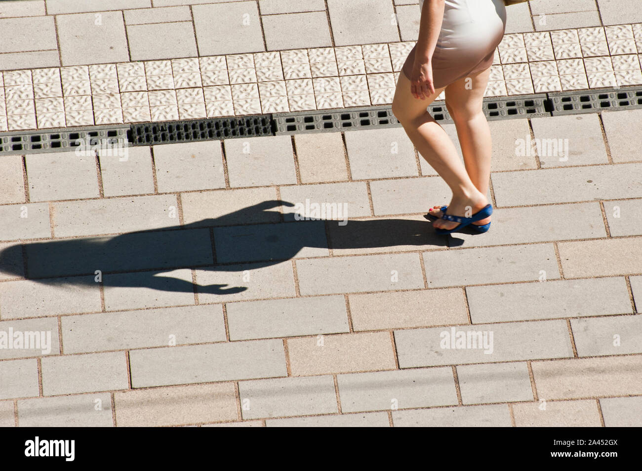 Frau mit kurzen Rock zu Fuß die Stadt Straße in einem Heißer Sommertag Stockfoto