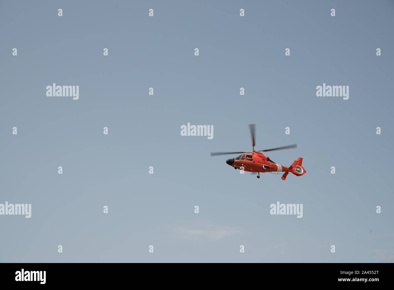 Orange Hubschrauber fliegen in einem wolkenlosen Himmel mit unscharfen Blades Stockfoto