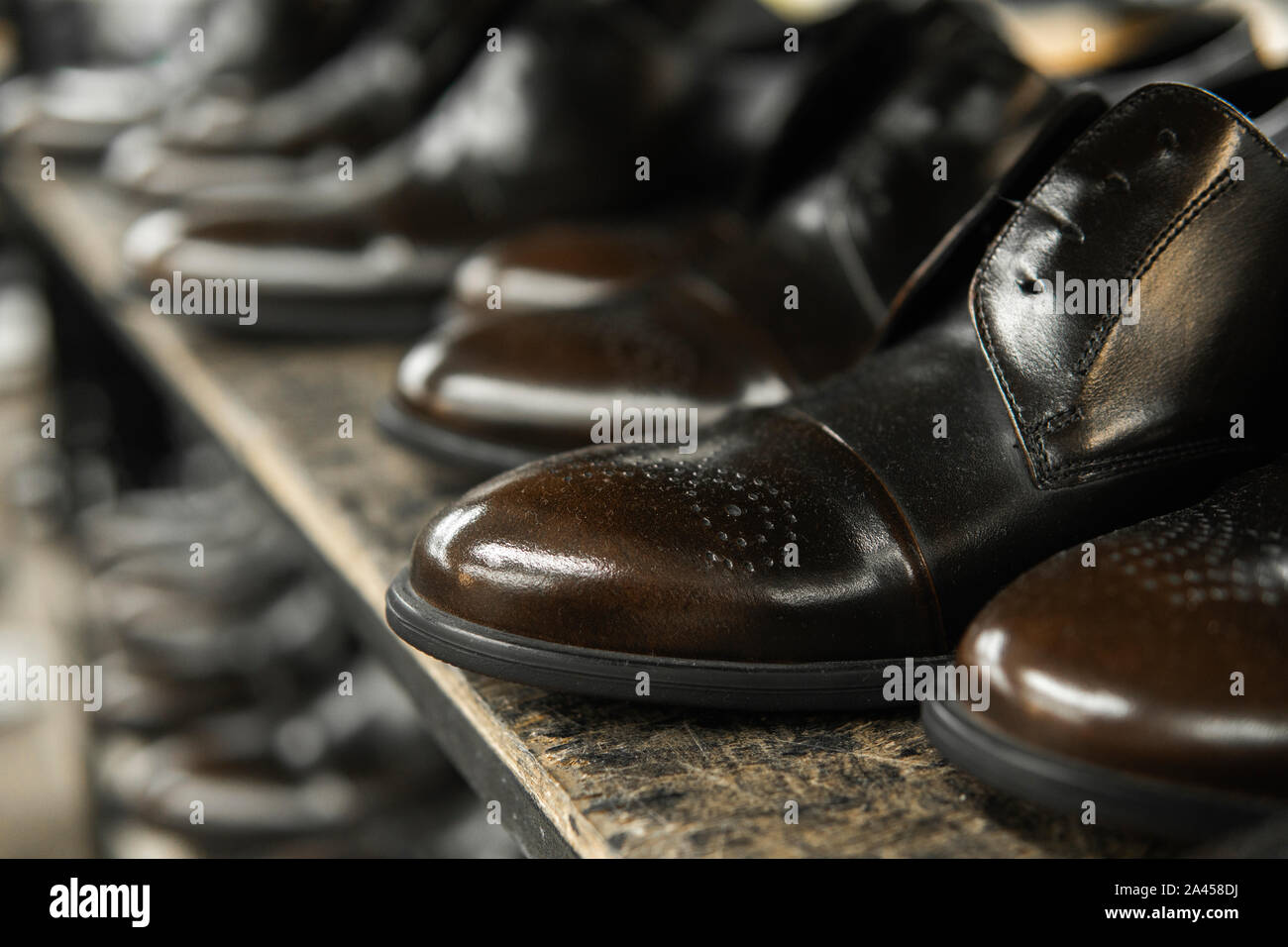 Eine Menge neue Schwarze glänzende Schuhe auf einem Regal. Schuhfabrik,  Fertigwarenlager Stockfotografie - Alamy