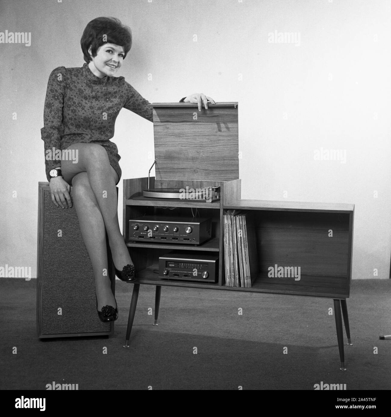 Modell mit kurzen Haaren stellt in einem mini-kleid mit Stereo Sound System c 1969 Foto von Tony Henshaw Archiv Stockfoto