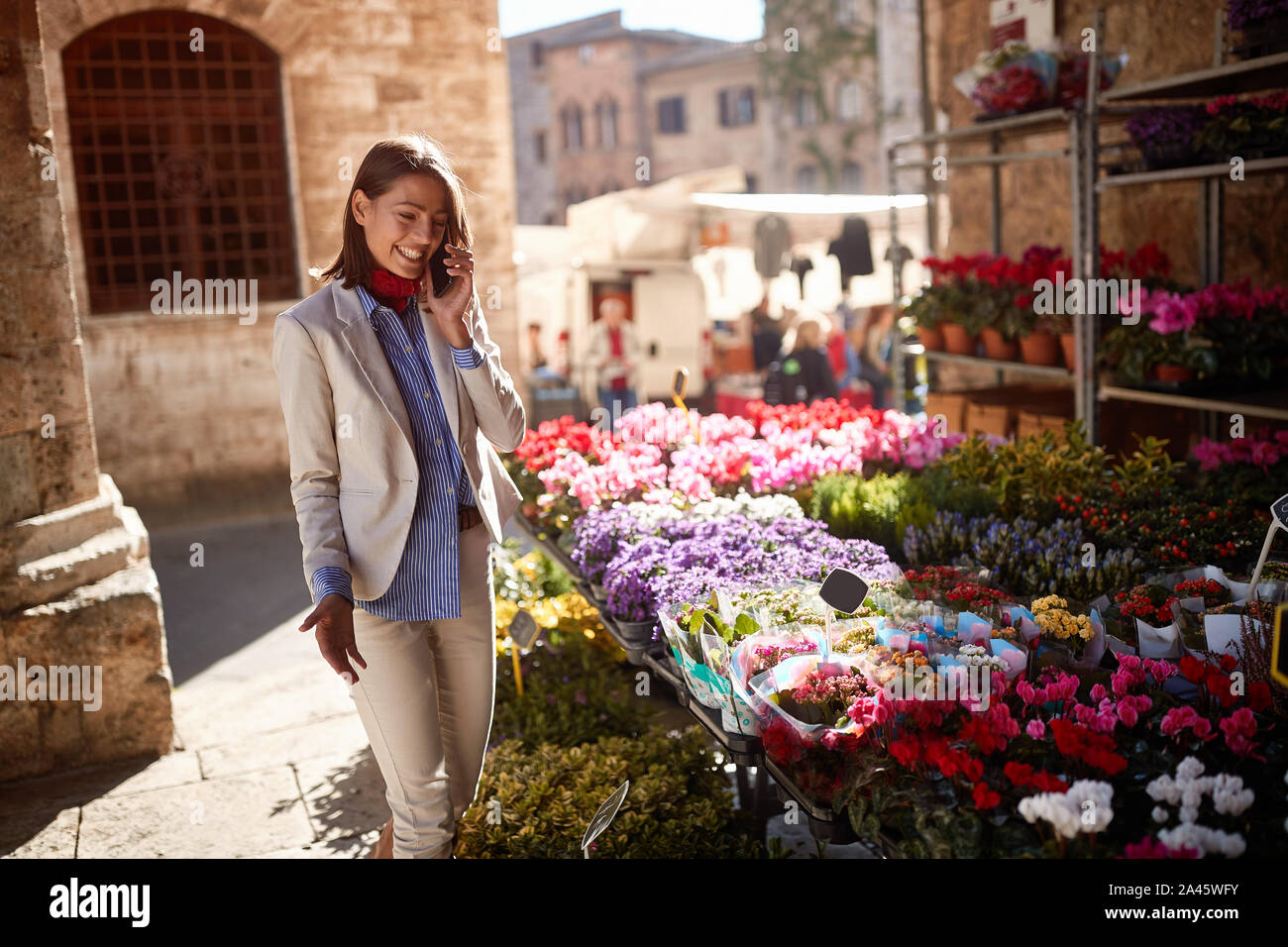 Lächelnde Mädchen kaufen Blumen Blumenladen auf der Straße. Stockfoto