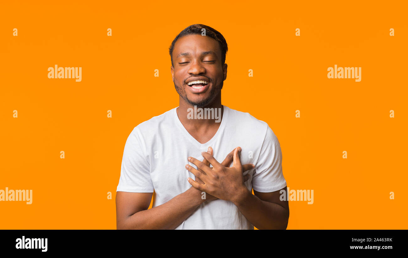 Afro Kerl, Hände auf der Brust stehen im Studio, Panorama Stockfoto