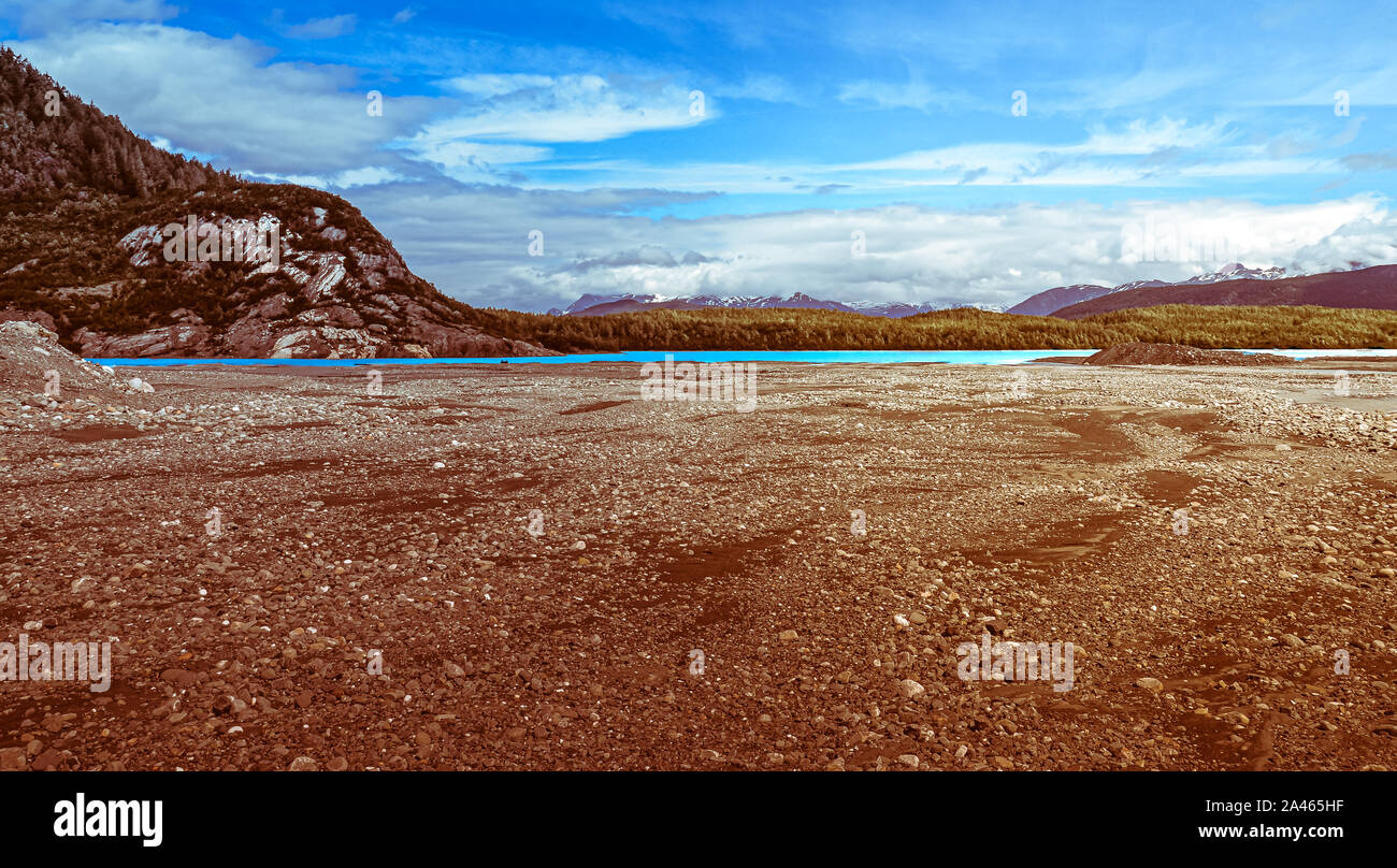 Panoramablick auf die Landschaft, der Fluss und die Berge in Alaska mit Gletscher zerkleinert Steine im Vordergrund. Stockfoto