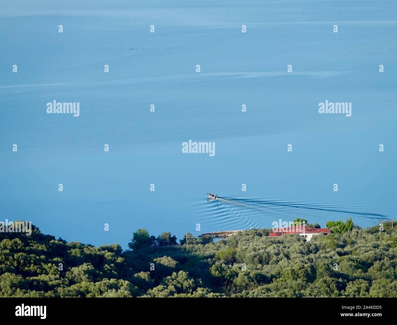 Fischer mit Boot, der das Ufer des Lesina-Sees verlässt und auf Muschelfarmen geht, Gargano Penninsula, Apulien, Italien. Stockfoto
