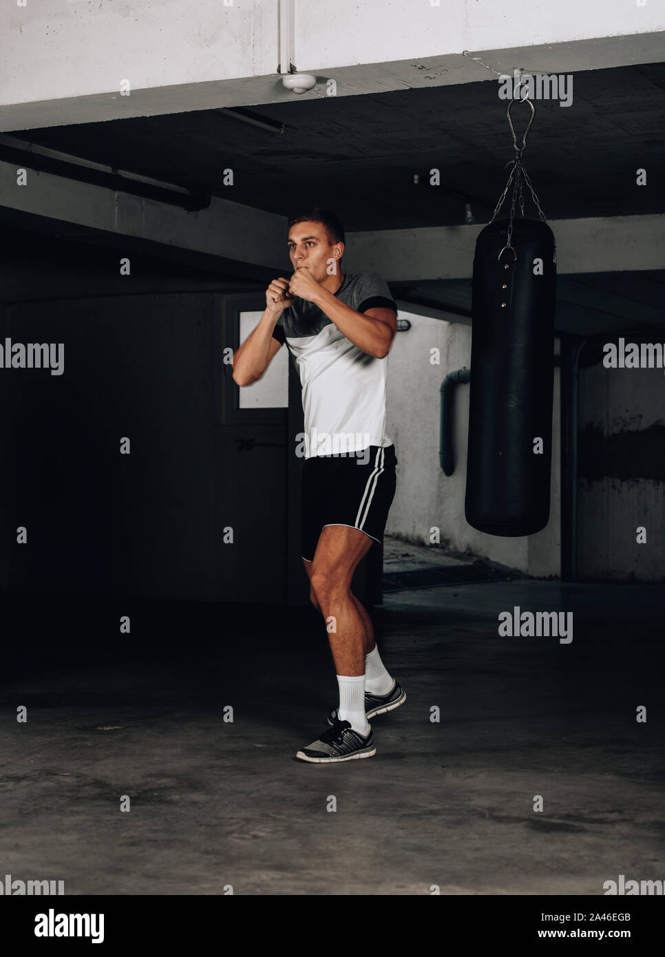 Muskulösen jungen Mann in Boxhandschuhe und Shorts zeigt die verschiedenen Bewegungen und Streiks Stockfoto