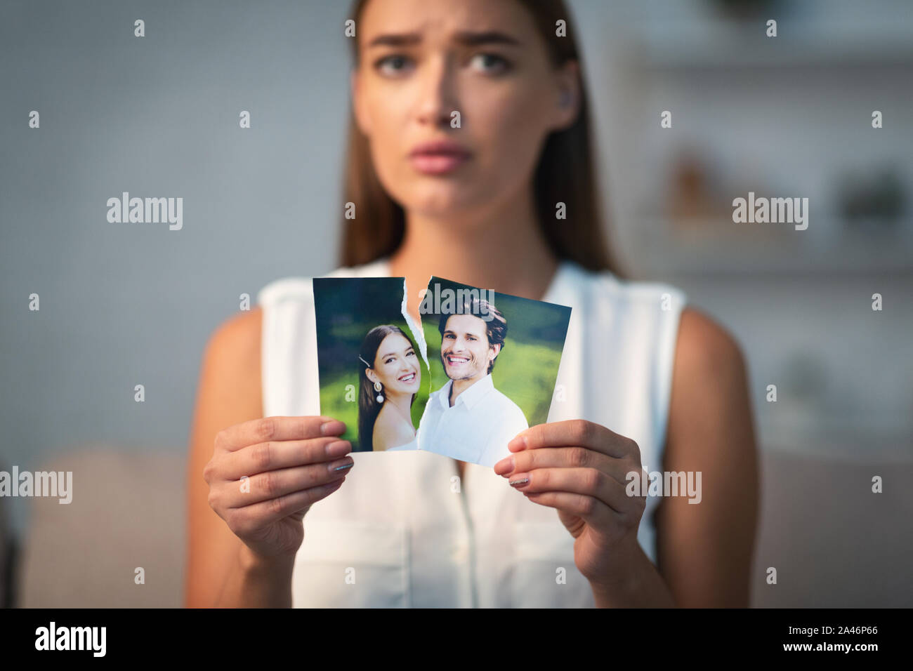 Trauriges Mädchen Ripping Foto mit Ex-Husband Indoor Stockfoto