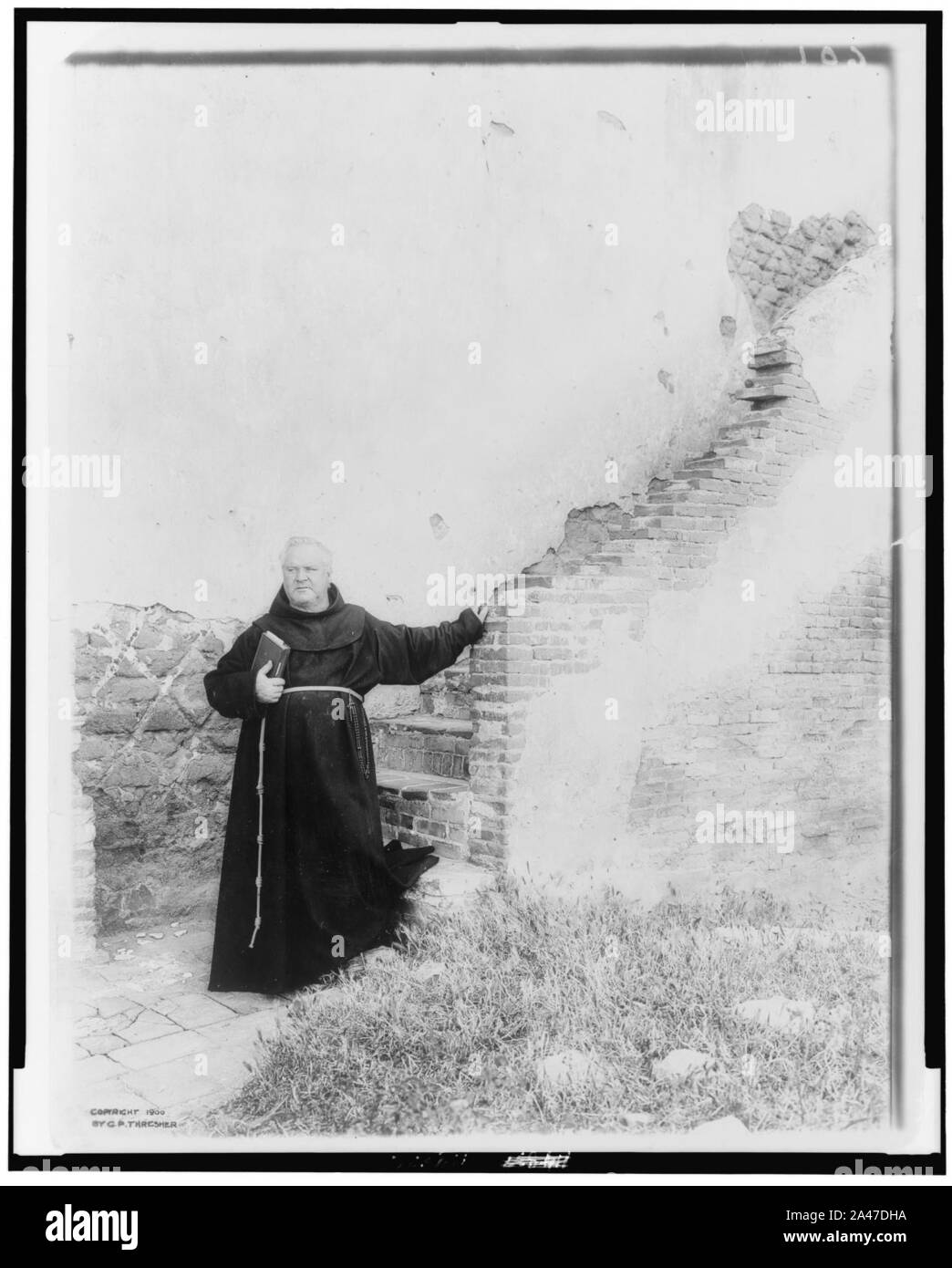 Pater O'Kief, ein Mönch, der sich in voller Länge, stehend an der Unterseite der Backstein Schritte der alte spanische Mission, Kirche San Luis Rey, Kalifornien Stockfoto